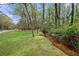 Lush backyard featuring mature trees and a tranquil creek running through the property at 3097 Sycamore Ln, Marietta, GA 30066