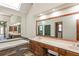 Bathroom featuring double vanities, a built-in tub with tiled surround, and large mirrors at 3684 Wittenburg Ct, Decatur, GA 30034
