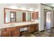 Bathroom featuring dual sinks, a large mirror, and wood cabinets with views into other rooms at 3684 Wittenburg Ct, Decatur, GA 30034