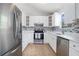 Modern kitchen with white cabinets, stainless steel appliances and mosaic tile backsplash at 4490 Thornwood Trl, Stone Mountain, GA 30083