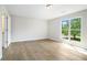 Bright bedroom with wood floors, a large window and a door to the bathroom at 4490 Thornwood Trl, Stone Mountain, GA 30083