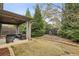 Backyard features a covered patio with a seating area and a landscaped yard with mature trees at 1895 Weston Ln, Tucker, GA 30084