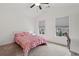 Bright bedroom with vaulted ceiling features a pink quilt bed, neutral carpet, and two windows at 1895 Weston Ln, Tucker, GA 30084