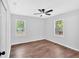Bedroom with laminate flooring, updated ceiling fan and two large windows at 484 Lorene Sw Dr, Marietta, GA 30060