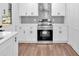 Modern kitchen features white cabinets, stainless steel appliances, and stylish wood flooring at 484 Lorene Sw Dr, Marietta, GA 30060