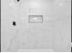 Modern shower featuring marble-patterned tiling and a built-in black storage niche at 484 Lorene Sw Dr, Marietta, GA 30060