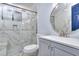 Bright bathroom featuring marble tiling, modern fixtures, and a glass-enclosed shower at 921 Creekdale Dr, Clarkston, GA 30021
