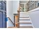 Inviting entryway with hardwood stairs, a wrought iron railing, and views into the kitchen at 921 Creekdale Dr, Clarkston, GA 30021