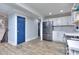 Open concept kitchen with stainless steel refrigerator, white cabinets, and hardwood floors at 921 Creekdale Dr, Clarkston, GA 30021