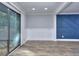 Open living room with hardwood floors, custom wall details, and sliding glass doors leading to the outside at 921 Creekdale Dr, Clarkston, GA 30021