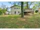Exterior view of the home's backyard featuring a deck, brick foundation, and mature trees at 3309 Poplar Dr, Lawrenceville, GA 30044
