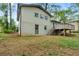 Exterior view of the home's backyard featuring a deck, brick foundation, and lush green lawn at 3309 Poplar Dr, Lawrenceville, GA 30044