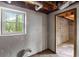 Unfinished basement featuring a window, exposed ceiling, and a doorway leading to another unfinished area at 3309 Poplar Dr, Lawrenceville, GA 30044