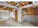Unfinished basement with a visible ceiling with exposed pipes, a door, and access to a garage space at 3309 Poplar Dr, Lawrenceville, GA 30044