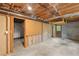 Unfinished basement featuring a door, exposed ceiling, and concrete flooring at 3309 Poplar Dr, Lawrenceville, GA 30044