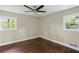 Bright bedroom with wood floors, a modern ceiling fan, and natural light streaming through two windows at 3309 Poplar Dr, Lawrenceville, GA 30044