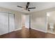 Bedroom with hardwood floors features a closet, neutral color palette, and adjoining bathroom at 3309 Poplar Dr, Lawrenceville, GA 30044