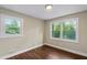 Cozy bedroom with wood floors, neutral paint, and natural light from dual windows at 3309 Poplar Dr, Lawrenceville, GA 30044