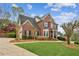 Beautiful red brick house with lush green lawn and mature trees in a suburban setting at 4155 Summit Gate Dr, Suwanee, GA 30024
