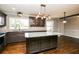 Spacious kitchen featuring dark cabinets, granite counters, stainless steel appliances, and hardwood floors at 5798 Salem Rd, Covington, GA 30016