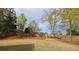 Spacious backyard with lush green grass, a wooded fence, and mulch beds at 2004 Westover Nw Ln, Kennesaw, GA 30152