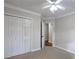 Bedroom with a ceiling fan, closet, and a doorway leading to another room at 2004 Westover Nw Ln, Kennesaw, GA 30152