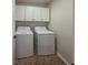 Convenient laundry room featuring a washer, dryer, and overhead cabinets for storage at 2004 Westover Nw Ln, Kennesaw, GA 30152