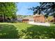 Expansive backyard with lush green grass, trees, and partial view of the brick home and garage at 2849 Livsey Woods Dr, Tucker, GA 30084