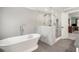 A bathroom featuring a soaking tub and a glass enclosed shower with grey tile flooring at 2849 Livsey Woods Dr, Tucker, GA 30084