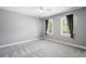A gray bedroom with large windows bringing in natural light and neutral carpet at 2849 Livsey Woods Dr, Tucker, GA 30084