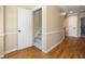 Hallway featuring a carpeted staircase, hardwood floors and white trim at 2849 Livsey Woods Dr, Tucker, GA 30084