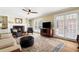 Comfortable living room featuring natural light, hardwood floors, ceiling fan and fireplace at 2849 Livsey Woods Dr, Tucker, GA 30084