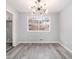 Bright dining room with modern light fixture, large window, and gray wood-look flooring at 3862 Northstrand Dr, Decatur, GA 30035