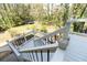 A stairway leads to the backyard from the back deck with white rails and black railings at 1468 Cheyenne Ct, Stone Mountain, GA 30087