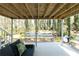 View of the covered back patio with exposed wood ceiling, and seating area at 1468 Cheyenne Ct, Stone Mountain, GA 30087