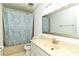 Neutral bathroom featuring a shower with blue pattern curtain, toilet and wide mirror above a large vanity counter at 1468 Cheyenne Ct, Stone Mountain, GA 30087