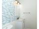 Half bath featuring blue tile accent wall, a modern sink, and white fixtures with stylish design at 1468 Cheyenne Ct, Stone Mountain, GA 30087
