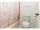 This bathroom features a tub with a pink shower curtain and a toilet with a towel rack at 1468 Cheyenne Ct, Stone Mountain, GA 30087