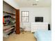 Bedroom with bed, dresser with TV, and open closet with shelves next to the window at 1468 Cheyenne Ct, Stone Mountain, GA 30087