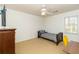 This bedroom includes carpet, a ceiling fan, closet, a twin bed, and a desk by the window at 1468 Cheyenne Ct, Stone Mountain, GA 30087