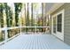 Wide shot of wood deck with natural surroundings and view of house siding with French doors at 1468 Cheyenne Ct, Stone Mountain, GA 30087