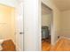 Bright hallway connecting to a powder room and a living area, showcasing hardwood floors and neutral tones at 1468 Cheyenne Ct, Stone Mountain, GA 30087