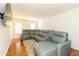 Spacious living room with modern gray sectional sofa, hardwood floors, and a mounted TV at 1468 Cheyenne Ct, Stone Mountain, GA 30087