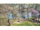 Backyard view through trees showcasing lush greenery and a tranquil pond, suggesting a peaceful retreat at 1510 Wood Thrush Way, Marietta, GA 30062