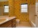 Bathroom with floral wallpaper, dark wood vanity, and window at 1510 Wood Thrush Way, Marietta, GA 30062