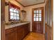 Butler's pantry with granite countertops, dark wood cabinets, a wine rack, and hardwood floors at 1510 Wood Thrush Way, Marietta, GA 30062