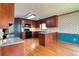 Kitchen featuring wood cabinets, granite countertops, black appliances, an island, hardwood floors, and wallpaper design at 1510 Wood Thrush Way, Marietta, GA 30062