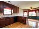 Kitchen features wood cabinetry, hardwood floors, neutral countertops, black appliances, and natural light from multiple windows at 1510 Wood Thrush Way, Marietta, GA 30062