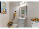 Charming powder room featuring a pedestal sink, decorative mirror, and sunflower accents at 4560 Evandale Way, Cumming, GA 30040