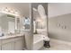 Bright bathroom featuring soaking tub, decorator mirrors and granite vanity at 4560 Evandale Way, Cumming, GA 30040